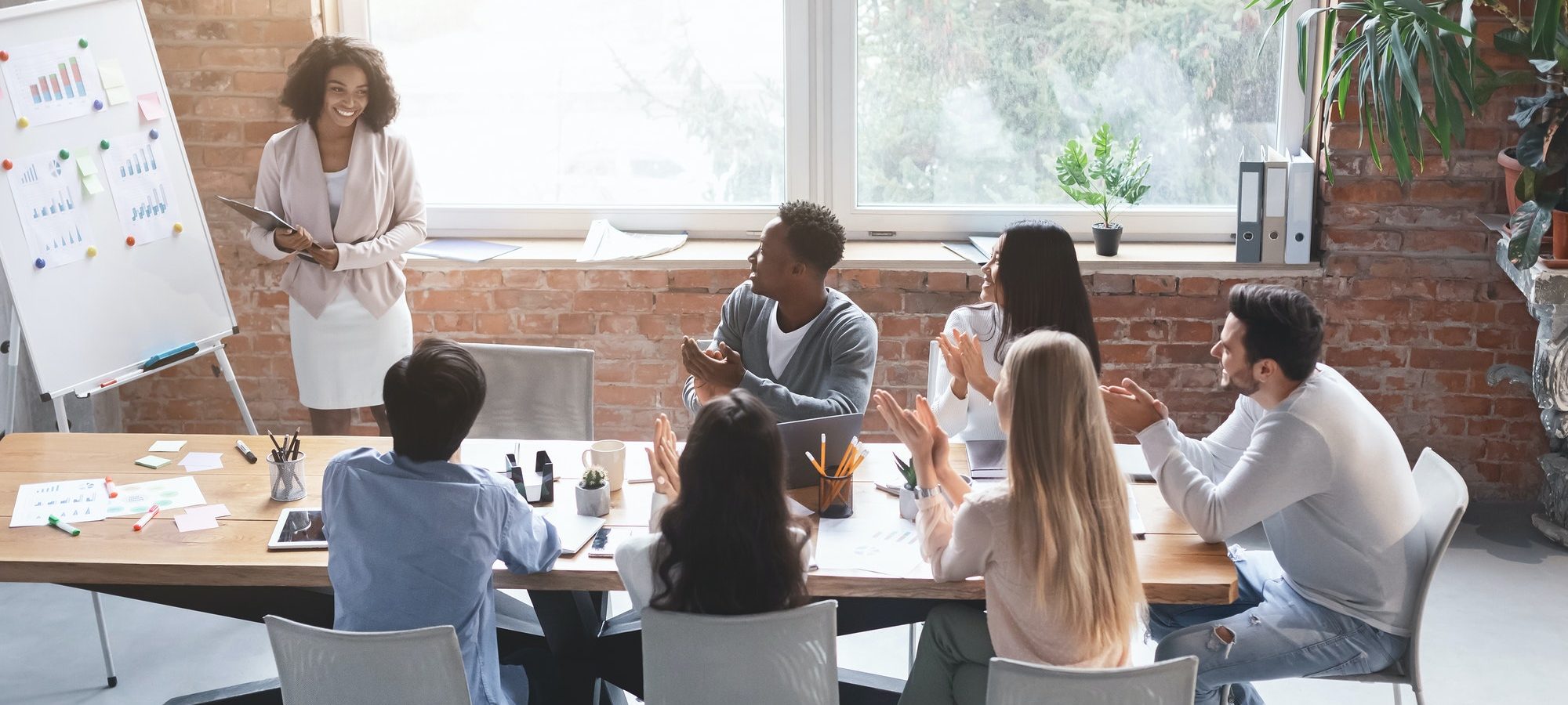 A women giving a presentation to a group of people seated at a conference table